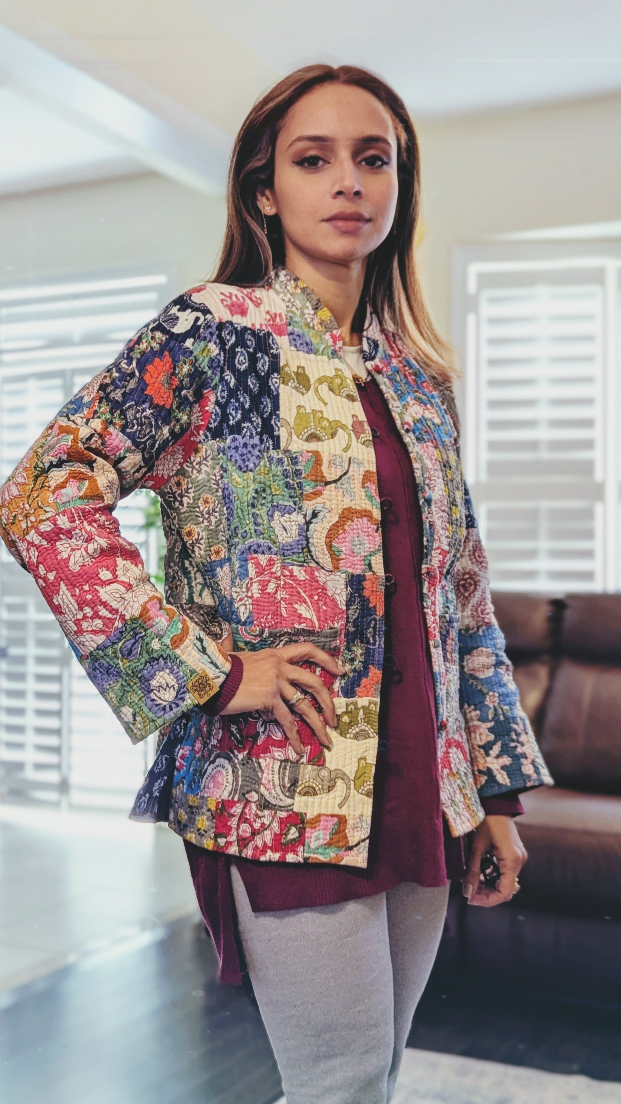 a woman showing reversible quilted cotton jackets with vibrant patchwork prints